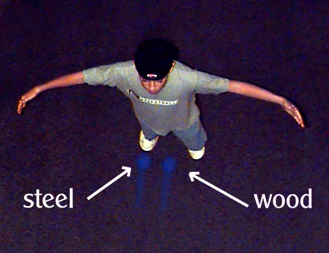Figure 6. The sphere demonstration. Two spheres of equal size but different material — one wood, one steel — thrown with the same velocity. The steel sphere, having the greater mass, strikes with the greater momentum.